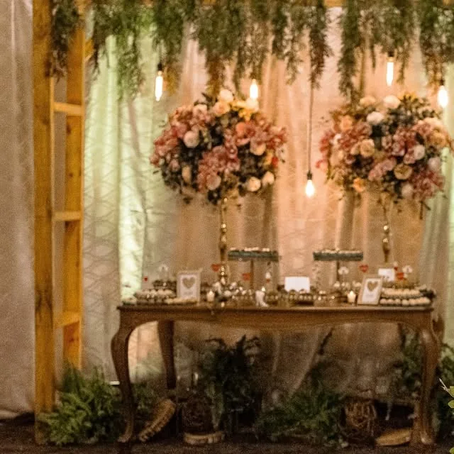 Mesa de doces com arranjos de flores